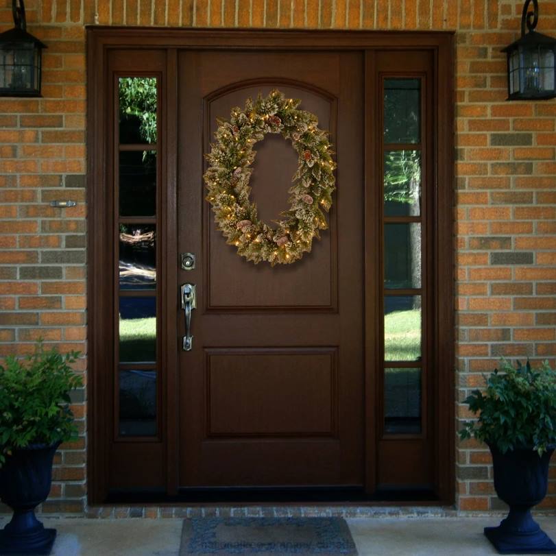 H4X0244National Tree Company Pre-Lit Artificial Christmas Oval Wreath, Green, Glittery Bristle Pine, White Lights, Decorated with Pine Cones, Frosted Branches, Christmas Collection, 21 Inches